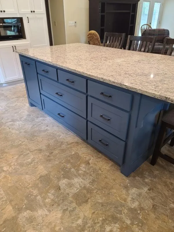 Kitchen island with a navy painted base and speckled granite top