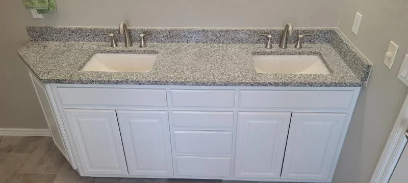 Double vanity with a granite top and white shaker cabinets
