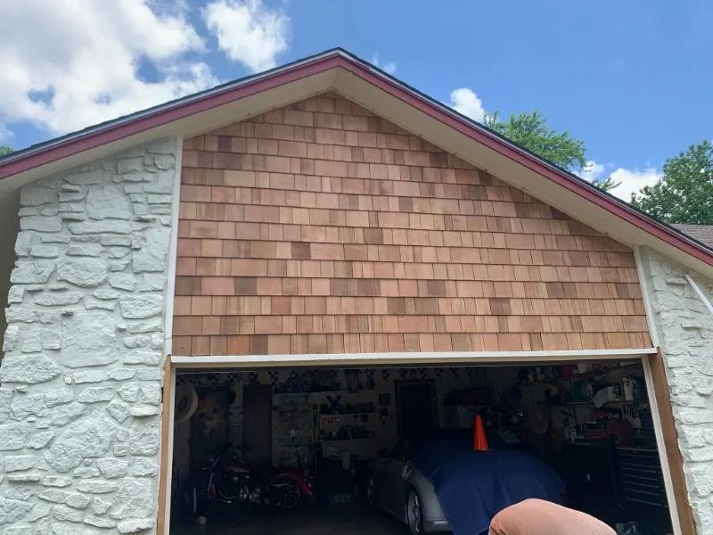 New cedar shake gable above a garage opening