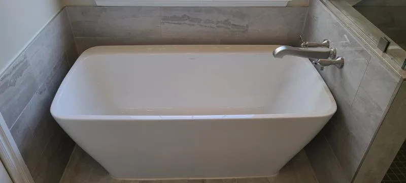 Freestanding soaking tub against large format wall tile