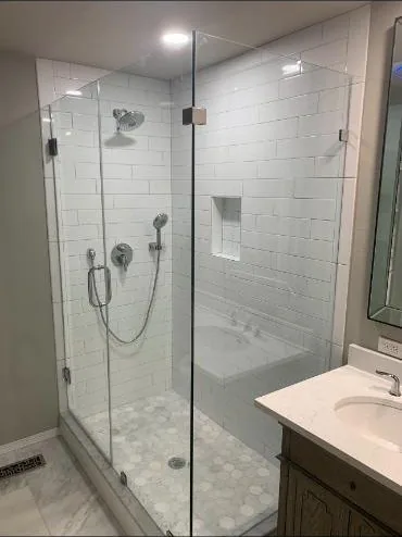 Glass shower enclosure with subway tile and a hex tile floor