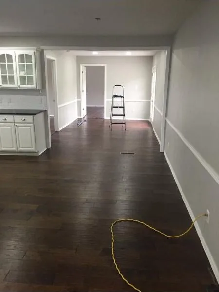 Hallway with newly laid wood flooring running toward a bright room